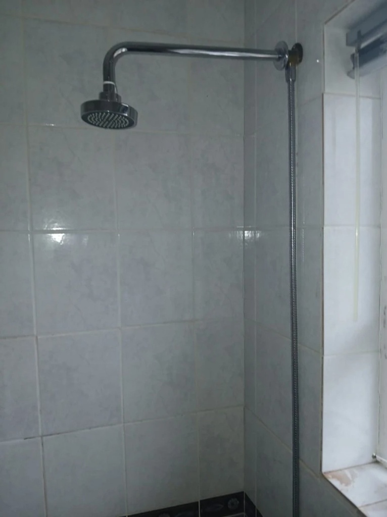 Shower head and mixer plumbing installed in a tiled shower